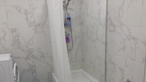 A bathroom with a shower, toilet, and washing machine. - Silicon Valley Apartments (Stari Grad, Belgrade)
