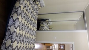 A room with a patterned curtain, a mirror reflecting the room, and a door leading to another area. - Silicon Valley Apartments (Stari Grad, Belgrade)