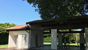 A covered outdoor area with a wooden deck, white walls, and a tiled roof. - Historic residence La Quassa Ispra Lake Maggiore (Ispra)