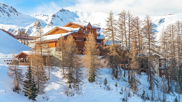 A snow-covered mountain lodge with multiple wooden buildings, surrounded by snow and trees. - Appartement avec balcon/terrasse | Accès piscine (Aime)