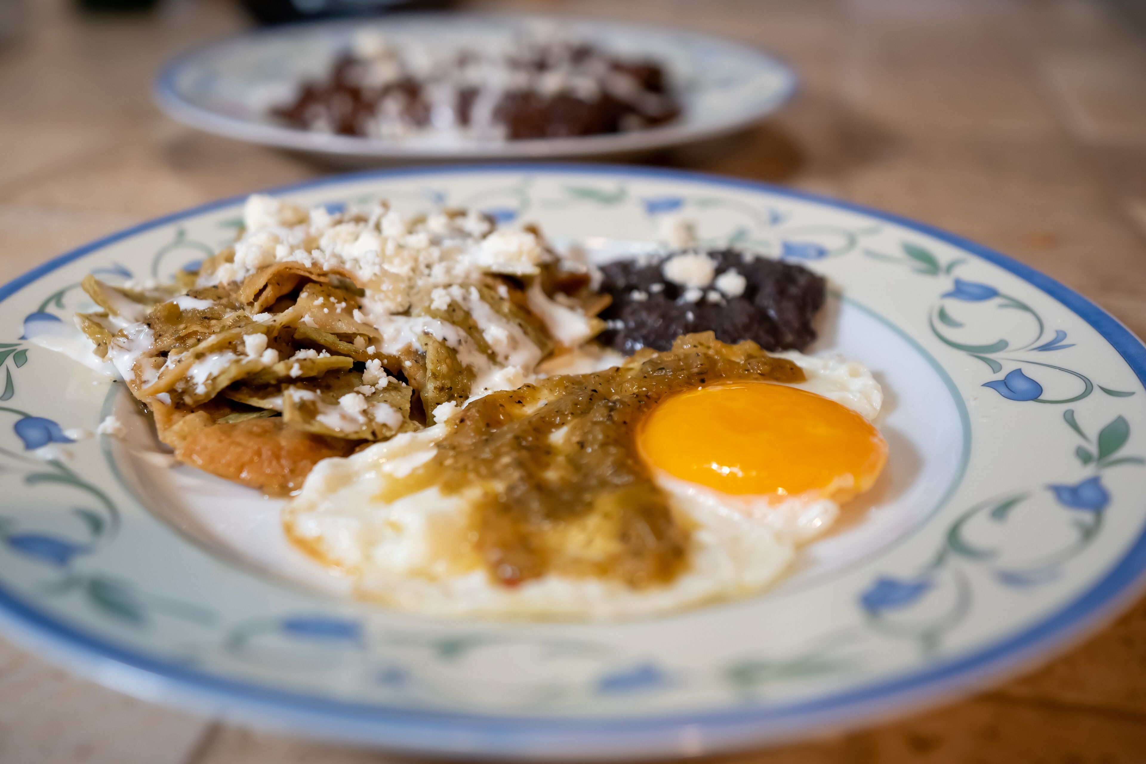 A plate with a fried egg, refried beans, and a slice of black pudding.