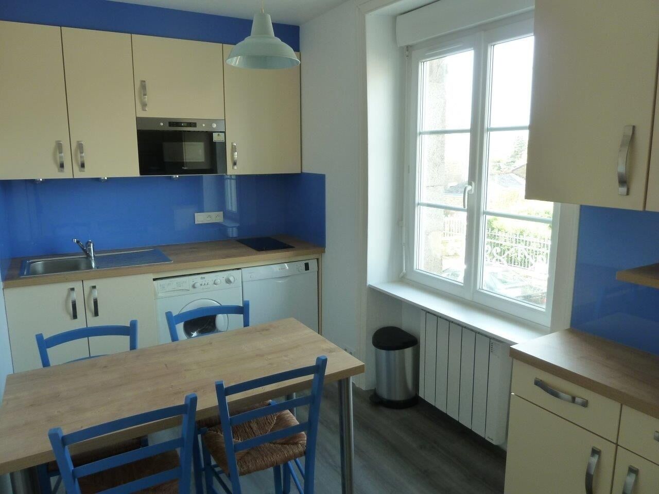 A compact kitchen with a sink, stove, and a window providing natural light.