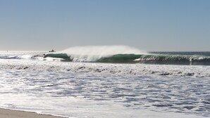 A beach with waves and a boat in the distance. - 1417G - "After Dune Delight" (Ventura)