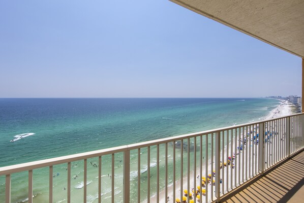 A balcony with a view of a beach and ocean.