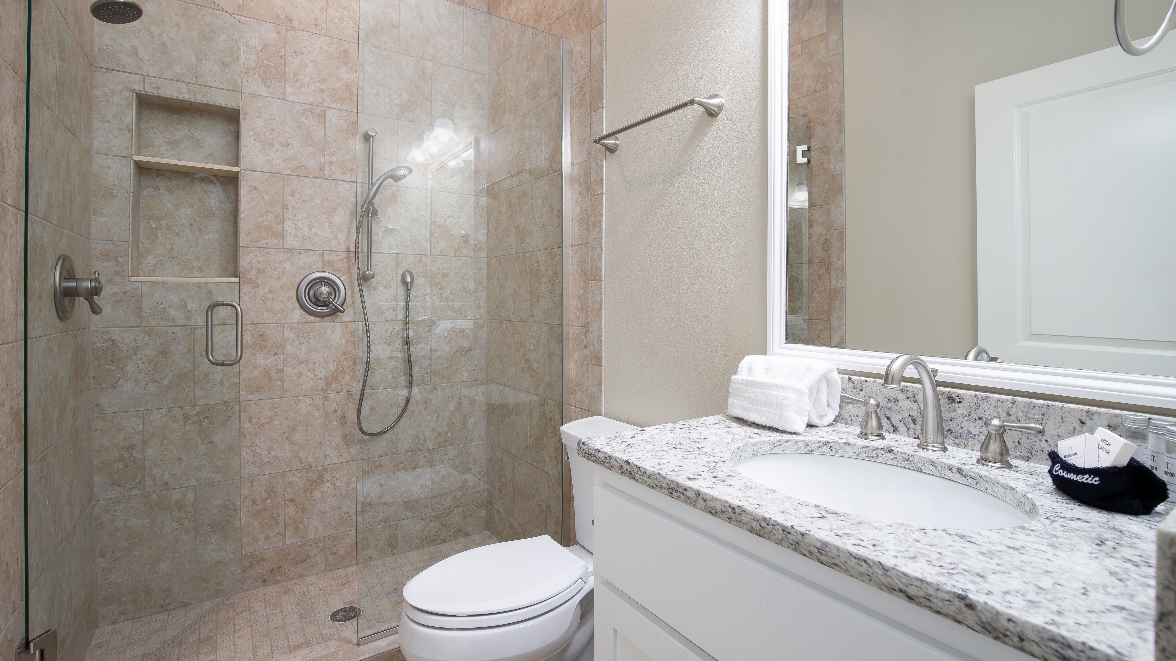 A modern bathroom with a shower, toilet, and sink.
