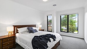 Una camera da letto con un letto, comodini, una finestra e vista sull'esterno.