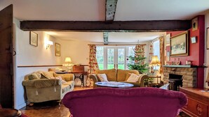 A cozy living room with a wooden ceiling, a fireplace, and a Christmas tree. - Private countryside cottage in Herefordshire (Hereford)