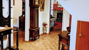 A spacious living room with hardwood flooring, a large wooden clock, and a fireplace. - Private countryside cottage in Herefordshire (Hereford)