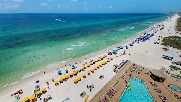 A beach resort with rows of sun umbrellas, a swimming pool, and a view of the ocean. - 1107-11th Floor-BEACH CHAIRS & UMBRELLA INCL-Outdoor Pool-AMAZING BEACH  VIEW! (Panama City Beach)
