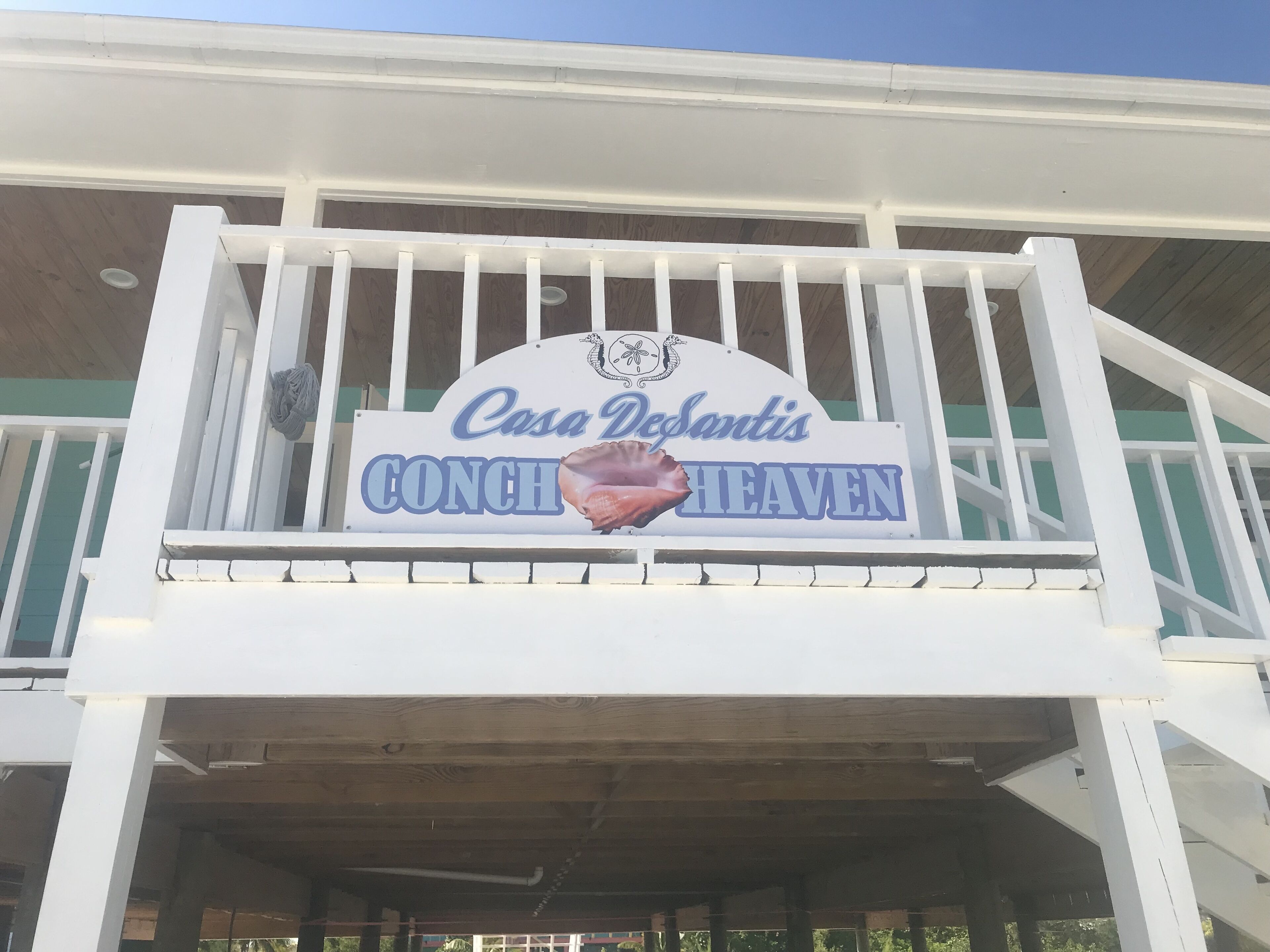 Une enseigne pour Casa DeSantis CONCH Heaven, avec un logo représentant un coquillage.