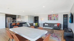 A modern living space with a dining area, kitchen, and seating area.