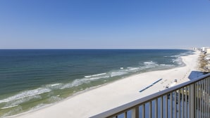 A beach view from a balcony with a railing, ocean waves, and a sandy shore. - 1211-12th Flr-2 Bedrooms-Sleeps 8-Outdoor Pool-Fitness Center-Hot Tub (Panama City Beach)