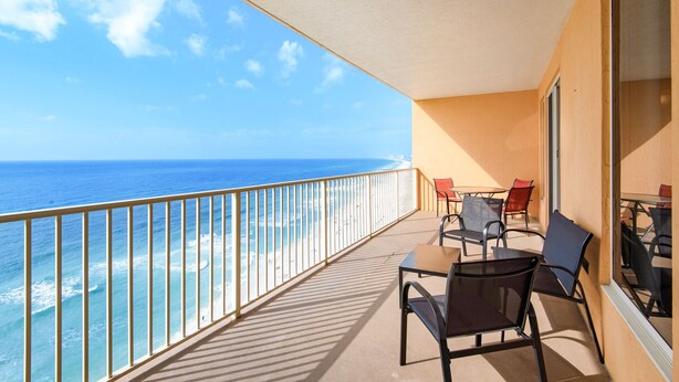 A balcony with a view of the ocean, equipped with a table and chairs. - 1211-12th Flr-2 Bedrooms-Sleeps 8-Outdoor Pool-Fitness Center-Hot Tub (Panama City Beach)