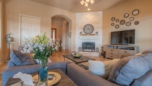 Una sala de estar con chimenea, televisor y sofá.