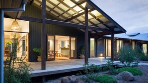 A modern house with a wooden deck, large windows, and a covered patio area. - Luxurious retreat in Pullenvale (Pullenvale)