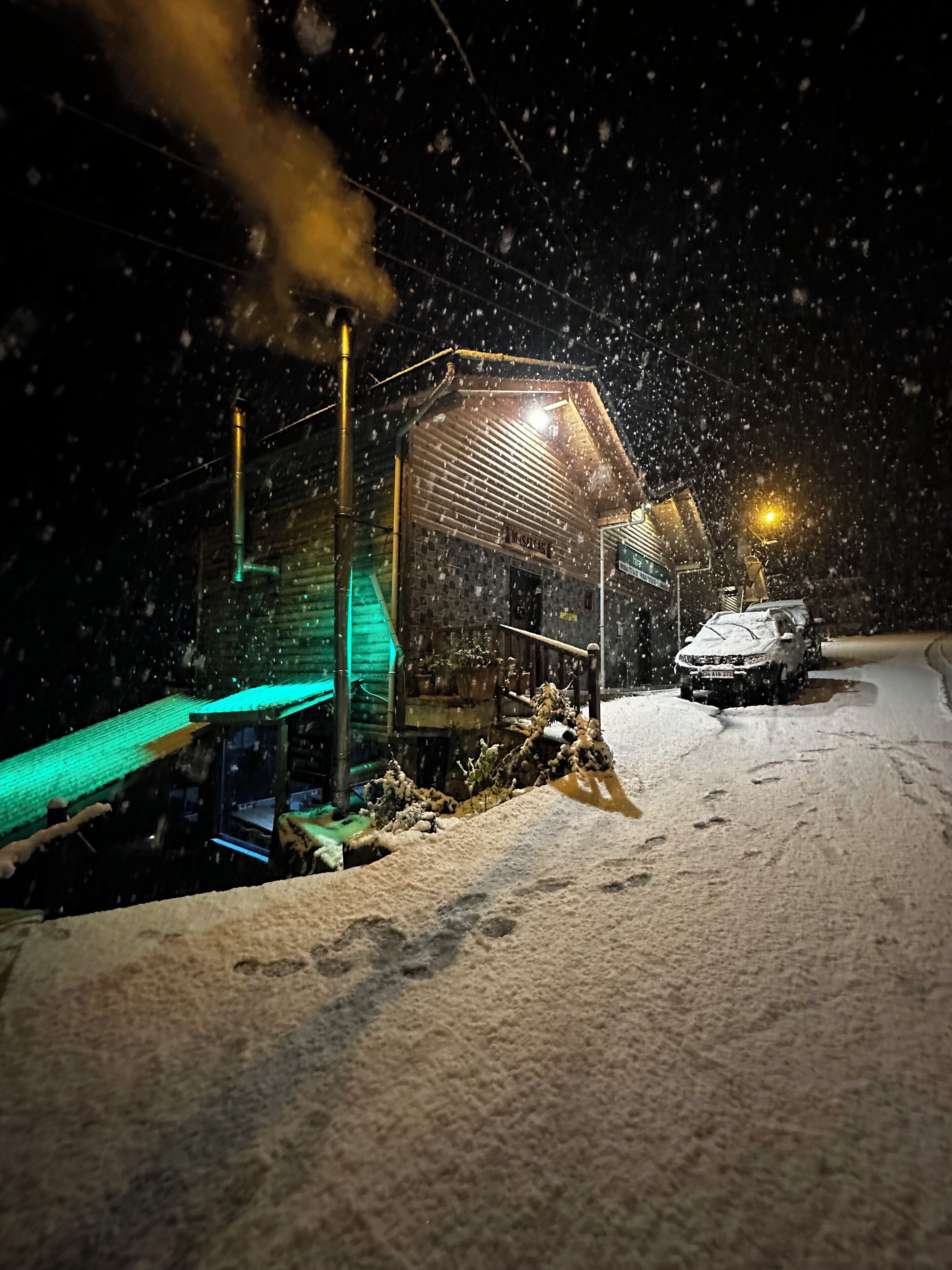 A snow-covered street at night with a building that has a sign reading "MASSIE".