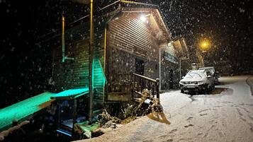 A snow-covered street at night with a building that has a sign reading "MASSIE".