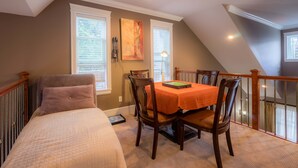 Un dormitorio con cama, una mesa de comedor con sillas y una ventana con persianas.