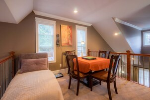 Un dormitorio con cama, una mesa de comedor con sillas y una ventana con persianas.
