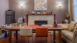 Un comedor con chimenea de piedra, refrigerador y sofá.