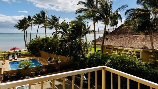 A pool area with a view of the ocean and palm trees. - Special December rates /Spectacular Ocean views 1Bed/2 bath (Kihei)