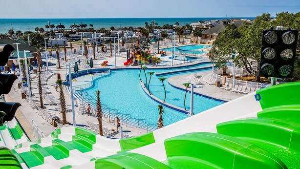 A resort with multiple swimming pools, a water slide, and beach chairs. - Comfortable 3 BR / 2 Bath n convenient location (Myrtle Beach)