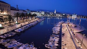 A marina with numerous boats docked, a promenade, and buildings in the background. - Close to Znjan beach, spacious studio with balcony (Split)