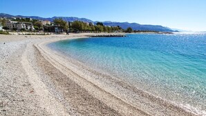 A pebble beach with clear water, a rocky shoreline, and buildings in the background. - Close to Znjan beach, spacious studio with balcony (Split)