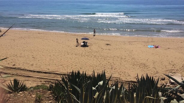 A beach with a clear sky, waves, and a few people. - Still White Beach **** Wonderful room facing the sea (Avola)