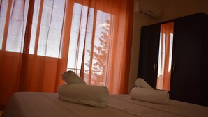 A hotel room with a bed, two rolled towels, and a wardrobe. - Still White Beach **** Wonderful room facing the sea (Avola)