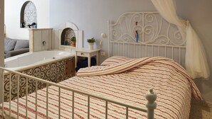 A bedroom with a bed, a nightstand, a vanity, a mirror, a window, and a bathroom with a bathtub. - Jerusalem Boutique holiday home in Katamon (Jerusalem)