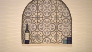 A wine bottle and two glasses on a decorative tile wall. - Jerusalem Boutique holiday home in Katamon (Jerusalem)
