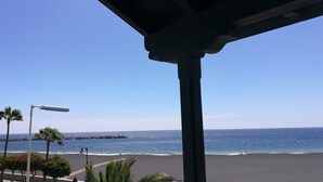 Une vue sur la plage depuis un espace abrité, avec un ciel dégagé.