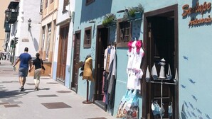 Une rue bordée d’immeubles, dont l’un porte une enseigne sur laquelle on peut lire « Sanlupe Indemnidad ».