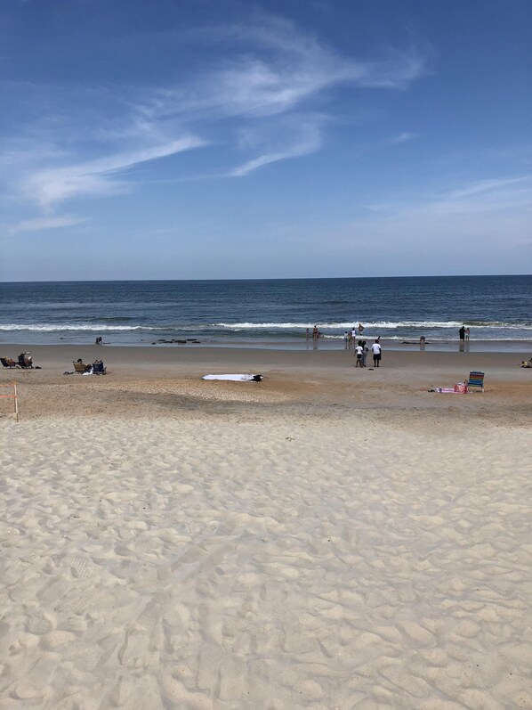 Perto da praia, espreguiçadeiras, guarda-sóis, toalhas de praia