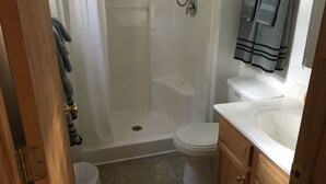 Un baño con ducha, inodoro y lavamanos.