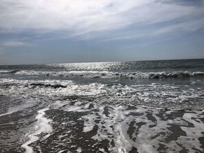 Une plage avec des vagues et un ciel dégagé.