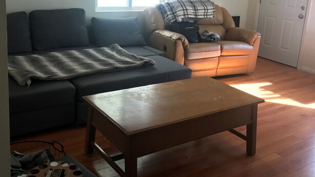 Un salon avec un canapé, une table basse et une fenêtre.