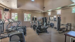 Ein geräumiges Fitnessstudio mit Laufbändern, Crosstrainern und Kraftgeräten.