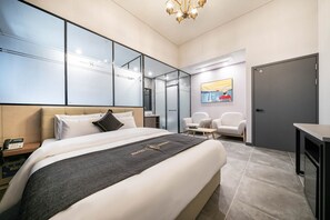 Una habitación de hotel moderna con una cama grande, un escritorio y una silla.