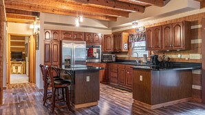 A spacious kitchen with wooden cabinets, a large island, and modern appliances.
