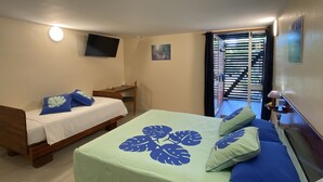 Un dormitorio con dos camas, un televisor montado en la pared y una ventana con persianas.