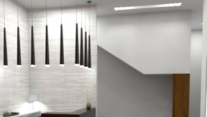 Un espace d’accueil moderne avec un sol en marbre, un comptoir d’accueil et des luminaires suspendus.