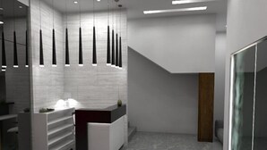 Une salle de bain moderne avec un sol en marbre, un meuble-lavabo blanc et un luminaire suspendu original.