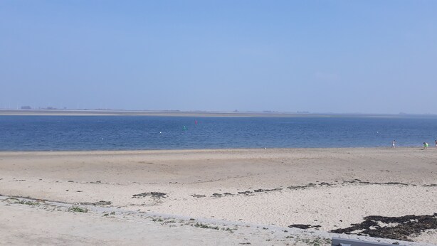 A beach with a sandy shore and calm water. - nice cozy home (Sint-Annaland)