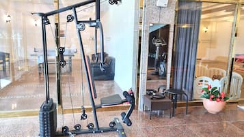A gym with a pull-up bar, weight stack, and exercise equipment.