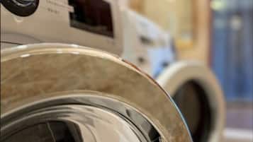 A row of front-loading washing machines in a commercial setting.