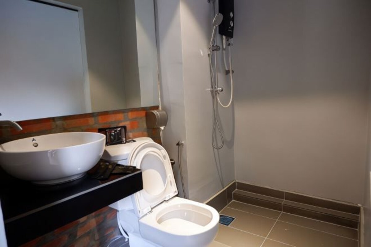 Un baño con lavamanos, inodoro y ducha blancos.