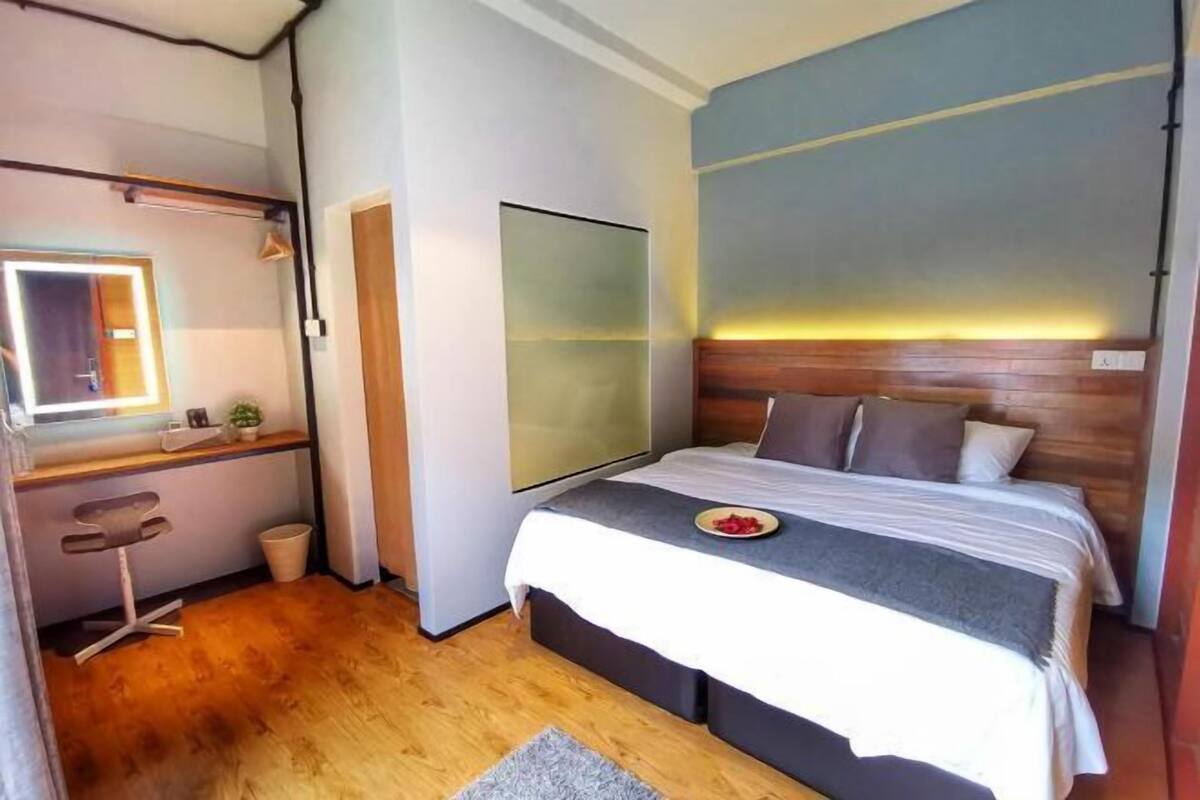 Ein Schlafzimmer mit Bett, Nachttisch und Spiegel.
