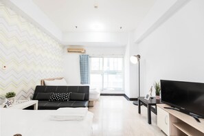 A modern living room with a black sofa, a flat-screen TV, a small table, and a large window with curtains. - Love Taipei - Ximen (Taipei)